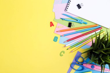 Okul konseptine geri dönelim. Sarı arka plan, boşluk ya da metin düzlüğü üzerine renkli kırsal okul malzemeleri