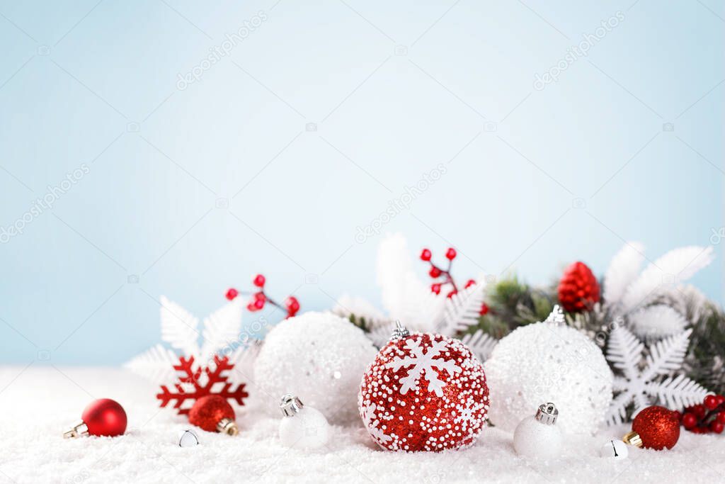 Christmas card template with festive red and white ornaments on the snow, blue background, lights bokeh, copy space 
