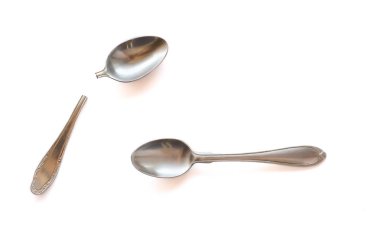 İki çay kaşığı ikiye ve beyaz bir arka plan üzerinde hizmete kırık - metal. Bireysellik toplum ve Aile kavramı.