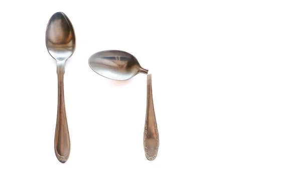 İki çay kaşığı ikiye ve beyaz bir arka plan üzerinde hizmete kırık - metal. Bireysellik toplum ve Aile kavramı.