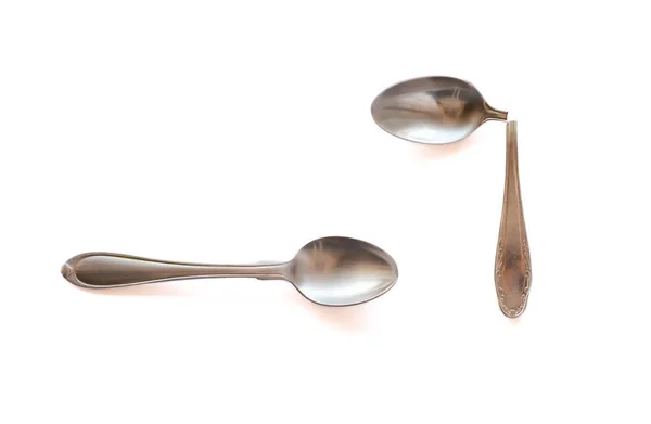 Two metal teaspoons - broken in half and serviceable on a white background. The concept of individuality in society and the family. — Stock Photo, Image
