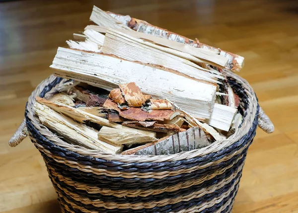 Oturma odasında bir hasır sepet içinde soğuk sezonunda bir ev ısıtma şömine için odun.