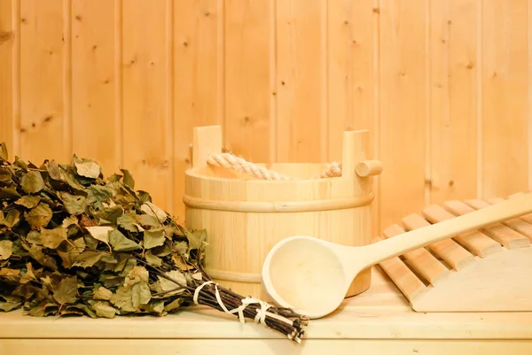 Tahta bir kova, bir huş süpürge ve diğer aksesuarları bir klasik Fin saunası veya Rus banyosu. Ahşap arka plan üzerinde boş alan