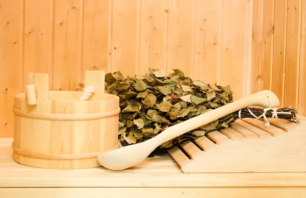 Tahta bir kova, bir huş süpürge ve diğer aksesuarları bir klasik Fin saunası veya Rus banyosu. Ahşap arka plan üzerinde boş alan