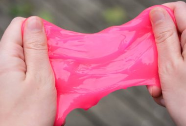 Ellerde pembe anti stres oyuncak balçık. Endişe ve stresle mücadele. Çocuklar için yaratıcı oyun deneyi.