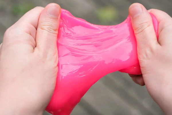 Ellerde pembe anti stres oyuncak balçık. Endişe ve stresle mücadele. Çocuklar için yaratıcı oyun deneyi.