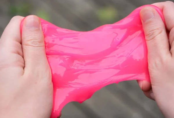 Ellerde pembe anti stres oyuncak balçık. Endişe ve stresle mücadele. Çocuklar için yaratıcı oyun deneyi.