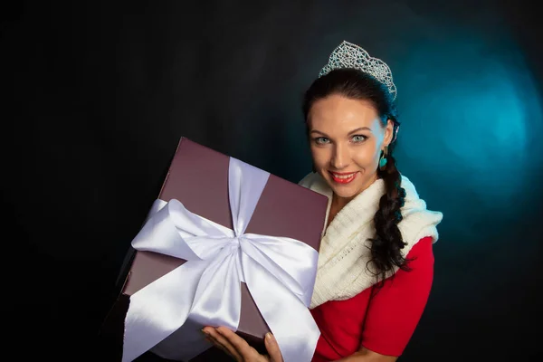 Snow Maiden, nieta de Santa Claus con un regalo en sus manos. Foto en el estudio sobre fondo negro. Feliz Año Nuevo . Imagen De Stock