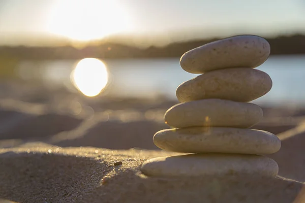 At dawn, the stones in the pyramid on the sand of the beach. The object is in focus, the background is blurred.