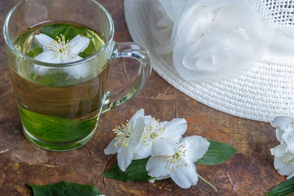 Nyári kalap, jázmin tea bögrében, virágok. Csendélet — Stock Fotó
