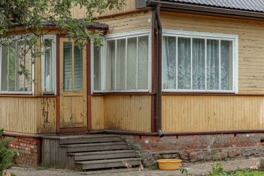 Eski ahşap bir binanın duvarının manzarası. Pencere. Boyalı tahtalardan yapılmış ev duvarları.