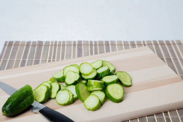 Sliced fresh cucumbers on a wooden board. Cooking concept — Stock Photo, Image