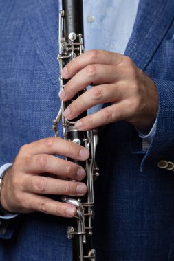 Klarnet tutan erkek ellerinin yakın çekimi, kesilmiş fotoğraf.,