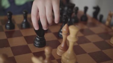 altı yaşında çocuk bir satranç tahtası üzerinde rakamlar düzenler