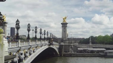 Alexander III Köprüsü, bulutlu gökyüzü, birçok kişi görünümü. Paris