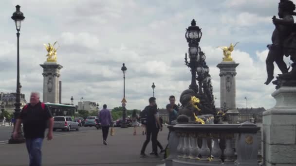 Ludzie chodzą na most Aleksandra Iii, pochmurne niebo, światło dzienne, wiele osób — Wideo stockowe