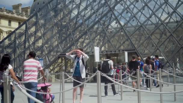 Línea a la taquilla del museo del Louvre. Pirámides, fuente. Turistas en la plaza — Vídeos de Stock