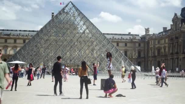 Muzeum Louvre, fontána. Turisté s fotografovat pyramidy na náměstí — Stock video