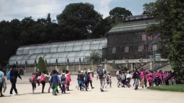 Volwassenen en kinderen in de botanische tuin in de buurt van greenhouse in Parijs — Stockvideo