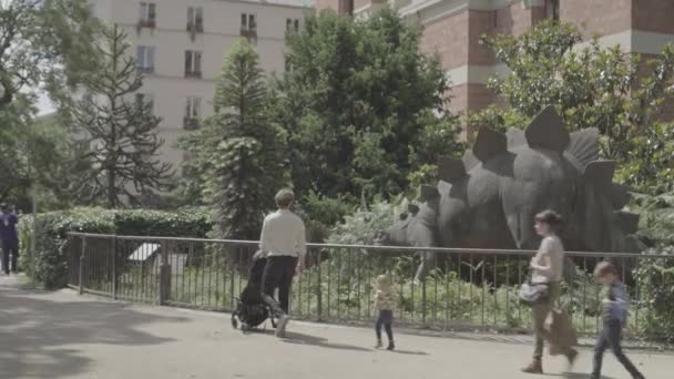 Człowiek z dzieckiem i patrząc na rysunek dinozaura w ogrodzie botanicznym w Paryżu — Wideo stockowe