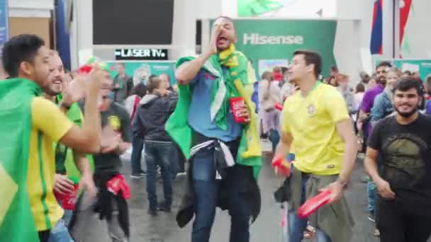 Обернитесь флагами счастливые бразильские фанаты поют и прыгают — стоковое видео