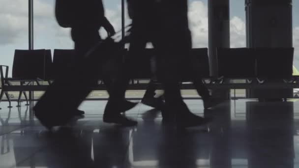 Siluetter av ben av skynda sig passagerare med resväskor på flygplatsen — Stockvideo