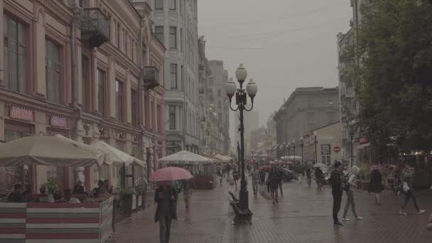 Люди ходят по улице Старого Арбата в дождливый летний день. Москва в центре — стоковое видео