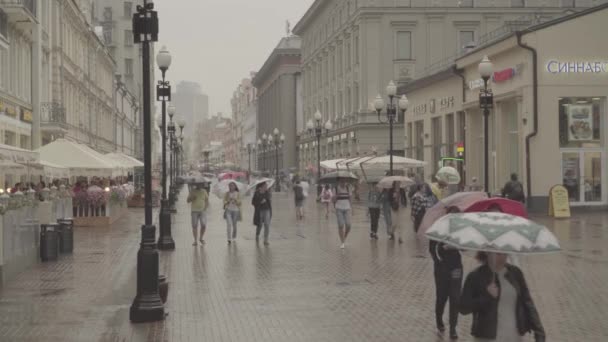 Люди ходят по улице Старого Арбата в дождливый летний день. Москва в центре — стоковое видео