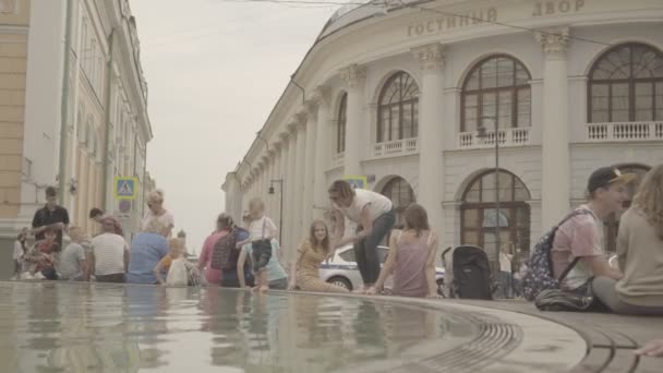 Люди отдыхают у фонтана возле Гостиного двора в Москве — стоковое видео