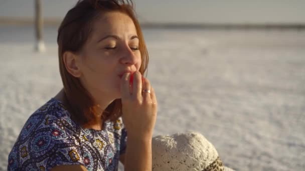 Gelukkig lachend meisje genieten van de zonsondergang, watermeloen, sit op zout, close-up eten — Stockvideo