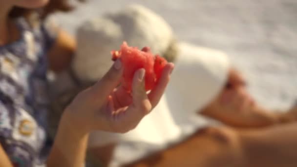 Menina sorridente feliz desfrutando do pôr do sol, comer melancia, sentar-se no sal, close-up — Vídeo de Stock