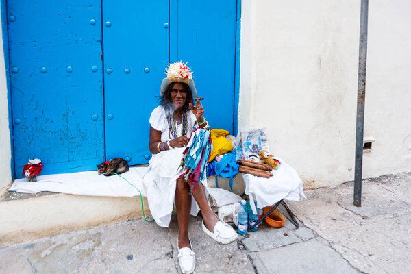 Charismatic Cuban in national costume with handmade cigars on Havana street