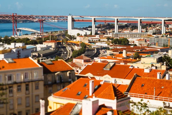 Wiele jasnych dachów w Lizbonie, 25 kwietnia most łączący się z Almada — Zdjęcie stockowe
