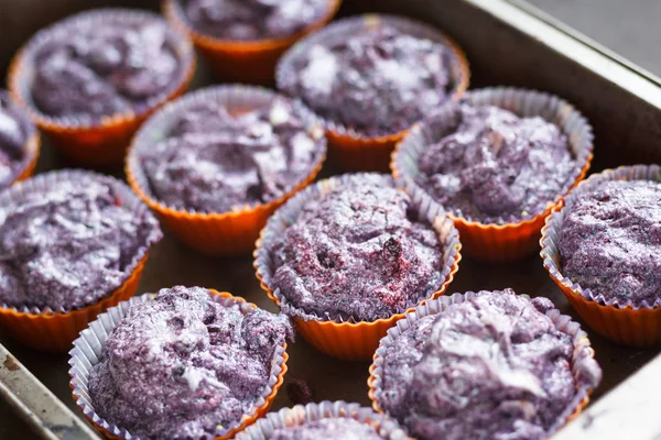Készítsünk gluténmentes áfonyák muffin. Nyers lila tészta sütőben konzervdobozok — Stock Fotó
