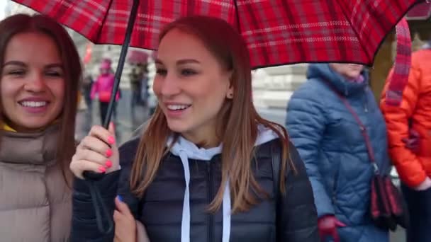 Zwei beste Freundin zu Fuß auf famouse nilolskaya Straße mit rotem Regenschirm — Stockvideo