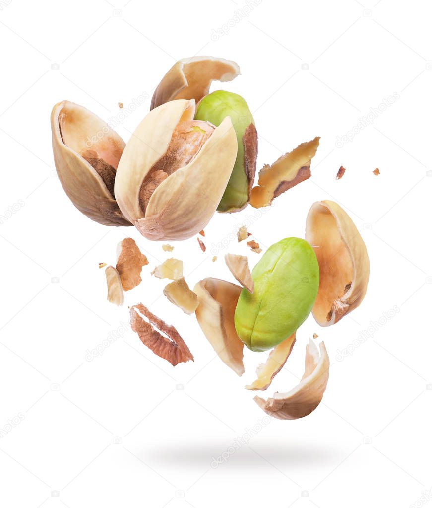 Pistachio crushed into pieces, frozen in the air on a white background