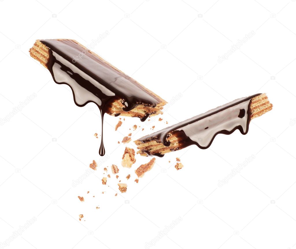 Waffles broken into two halves and poured with chocolate isolated on a white background