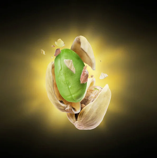 A cracked pistachio with a flash of light in the dark