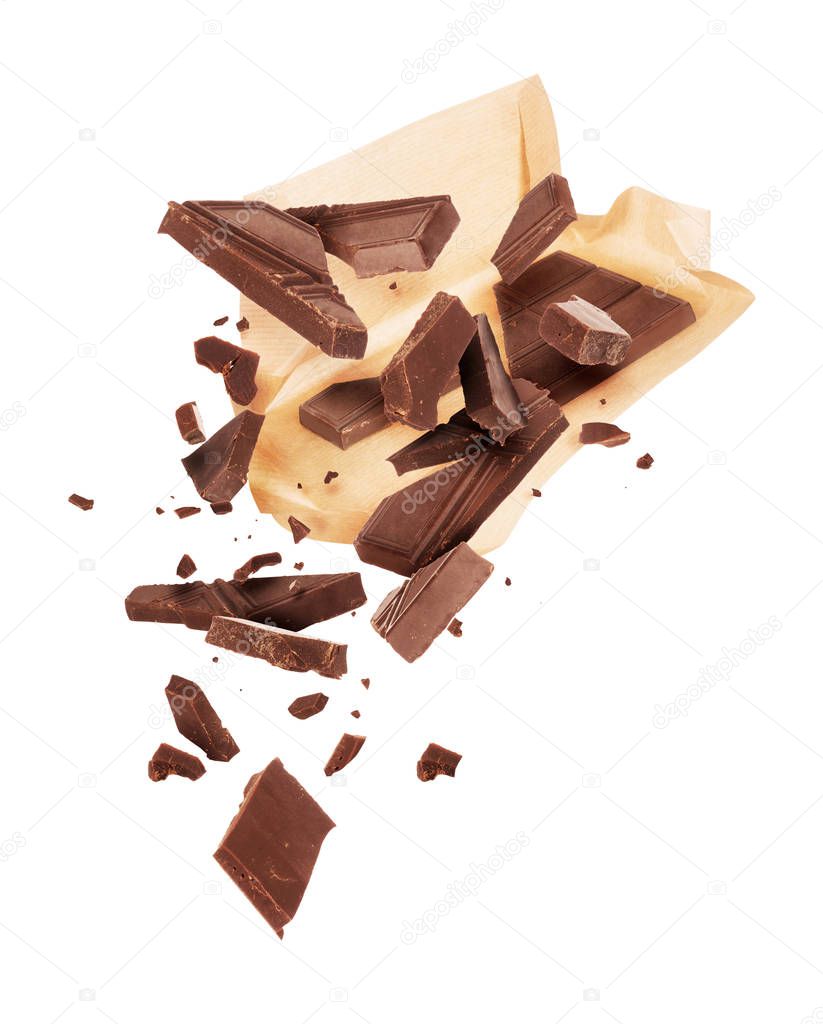 Pieces of crushed chocolate are fly out of a paper wrapper