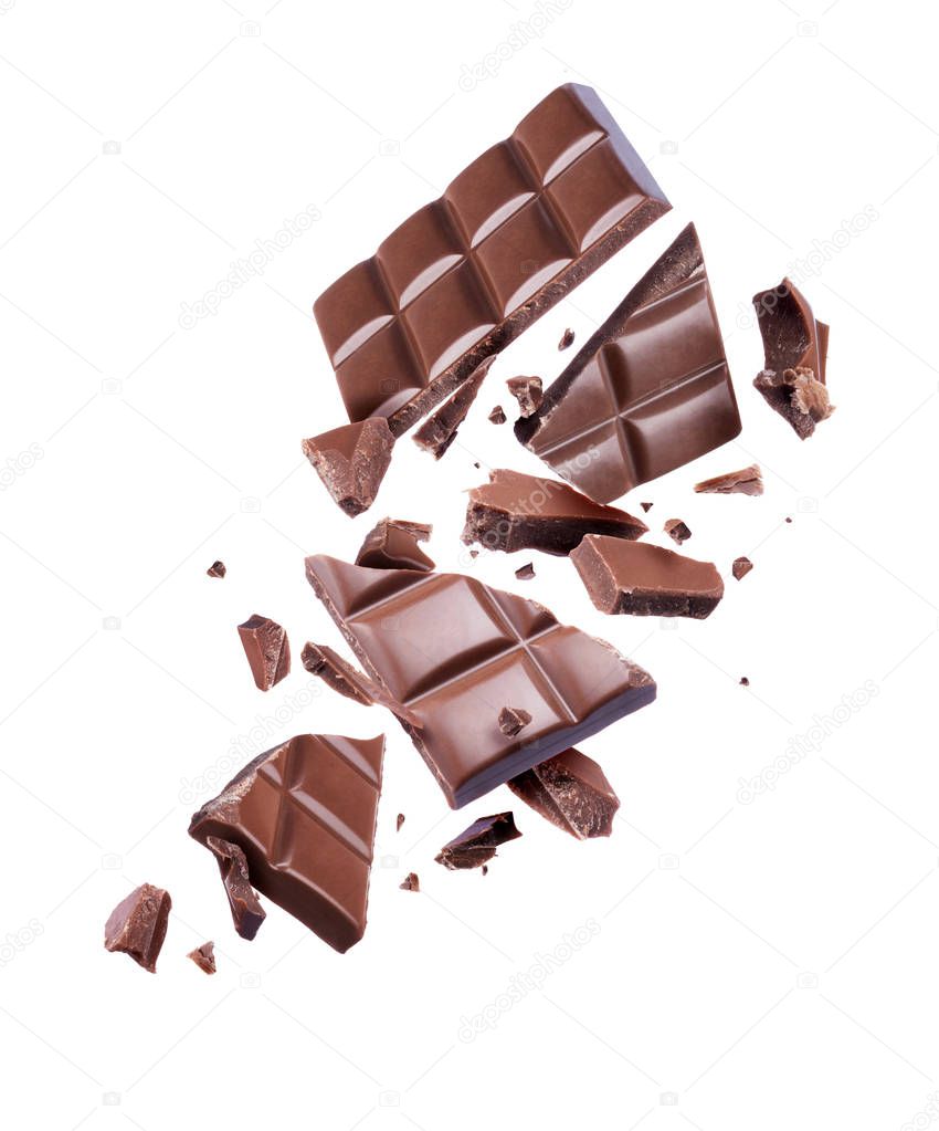 Chocolate broken into many pieces in the air on a white background