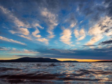 Göl üzerinde büyüleyici renkli günbatımı