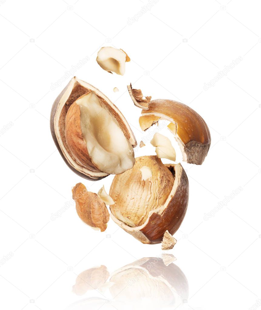 Hazelnuts crushed in the air on white background