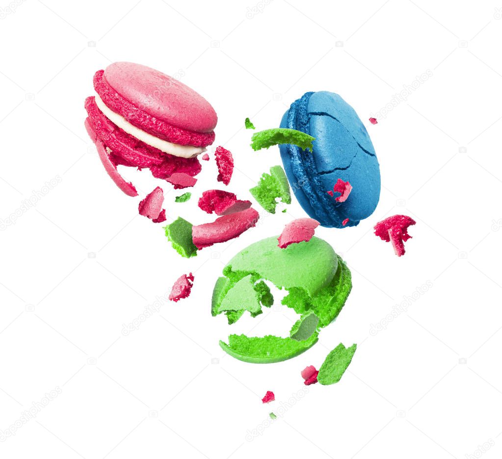 Colorful macaroons are torn to pieces in the air isolated on a white background