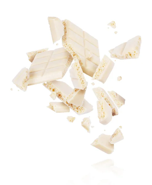 Σπασμένα πορώδη Λευκή σοκολάτα πέσει κάτω απομονωθεί σε λευκό φόντο — Φωτογραφία Αρχείου