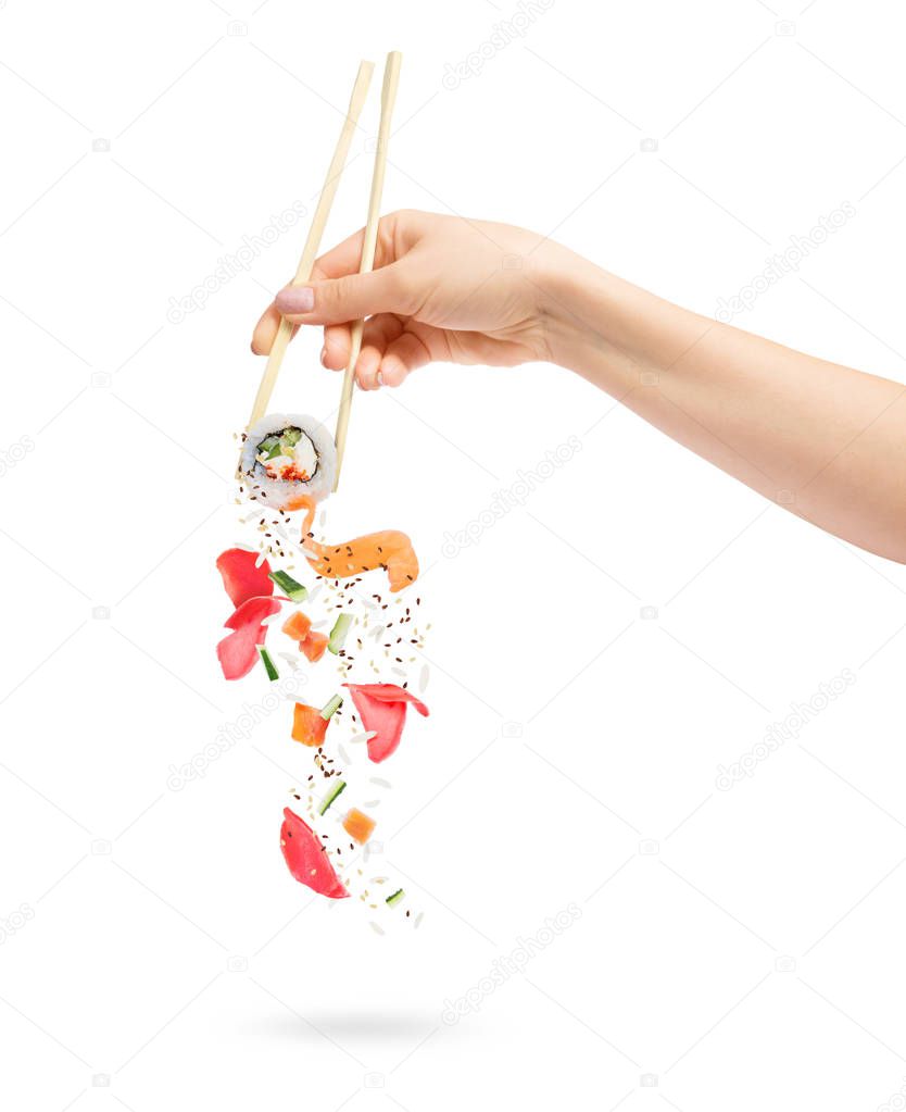 Unfolded sushi roll with ingredients chopsticks in female hand on white background 