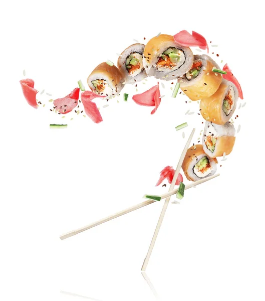 Rollos de sushi fresco con jengibre congelado en el aire sobre fondo blanco —  Fotos de Stock