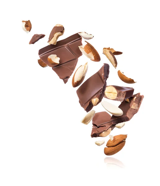 Pedaços de barra de chocolate com amêndoas caindo, isolado em fundo branco — Fotografia de Stock