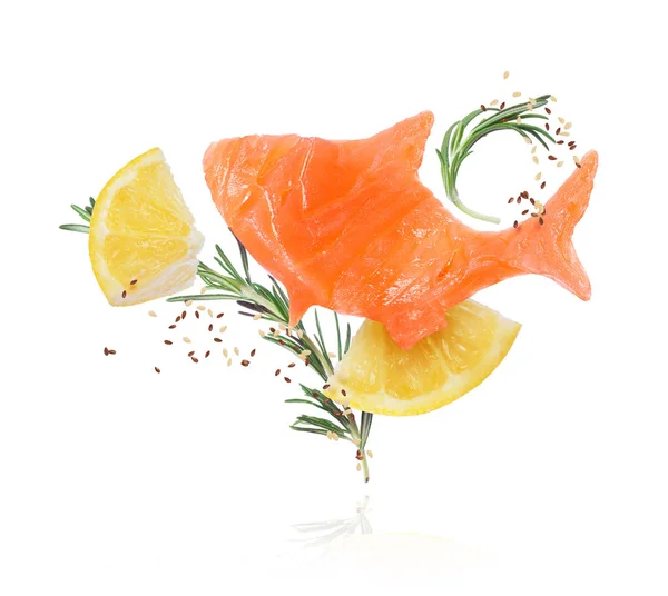 Imagen conceptual de un trozo de pescado rojo con romero y trozos de limón de cerca sobre fondo blanco — Foto de Stock