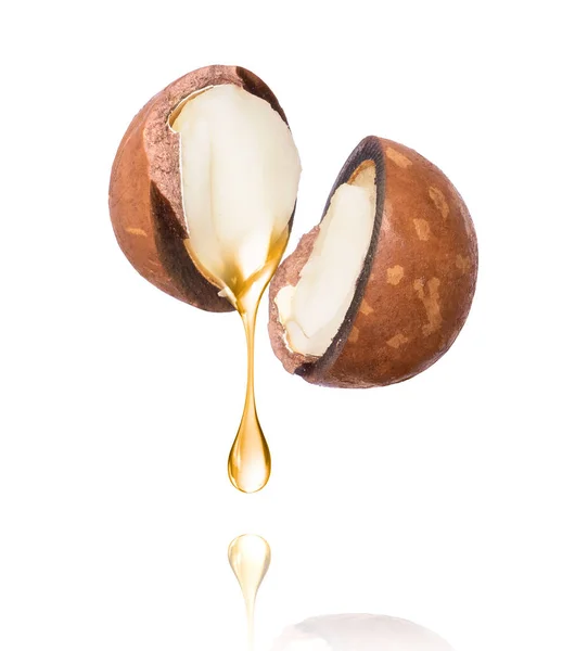 Olio di noce di macadamia gocciola su fondo bianco . — Foto Stock