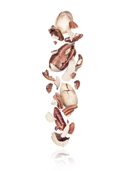 Spruckna pecan nötter faller ner isolerade på vit bakgrund — Stockfoto